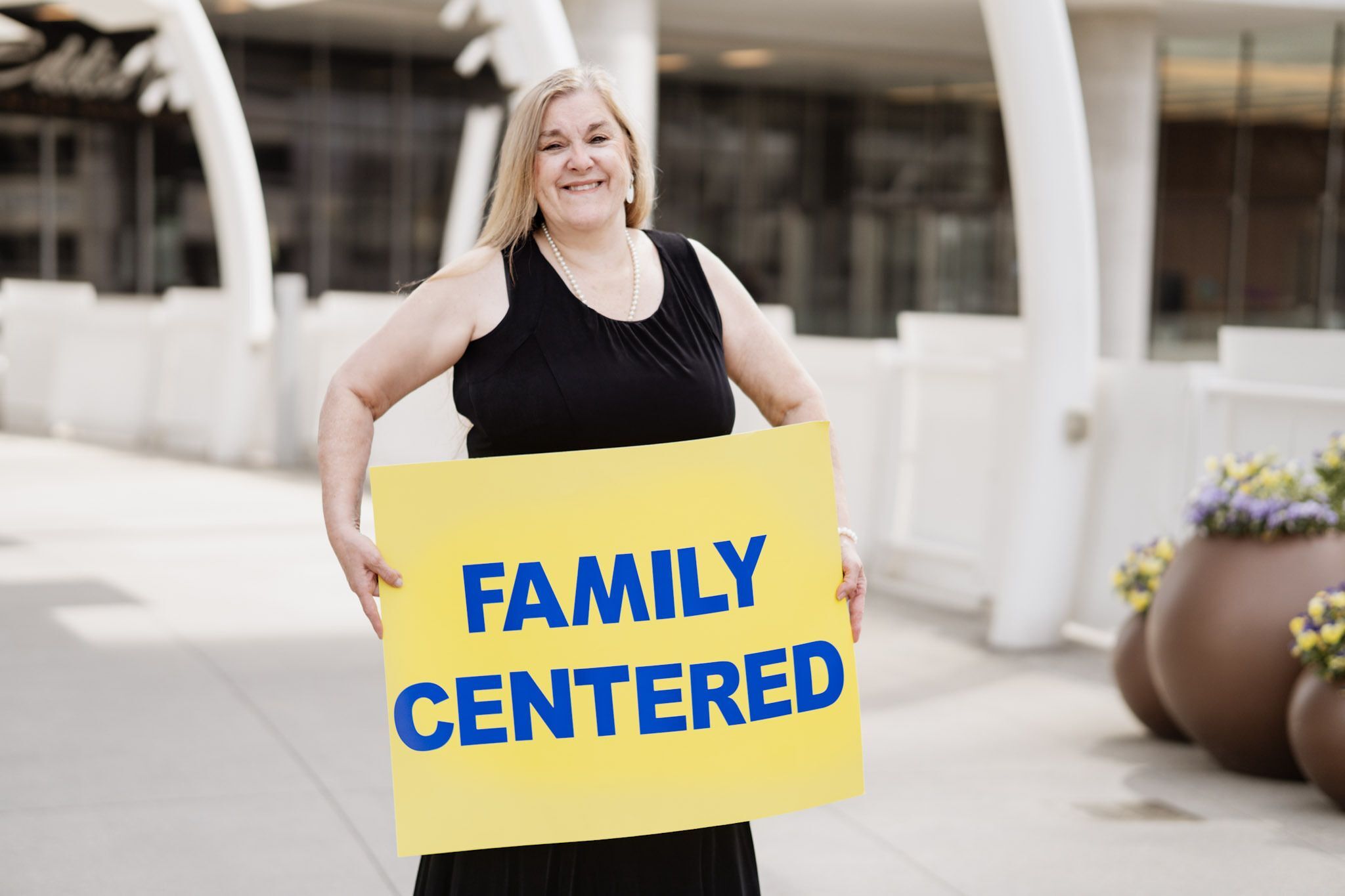Gena Bunney holding a sign that says "Family Centered"
